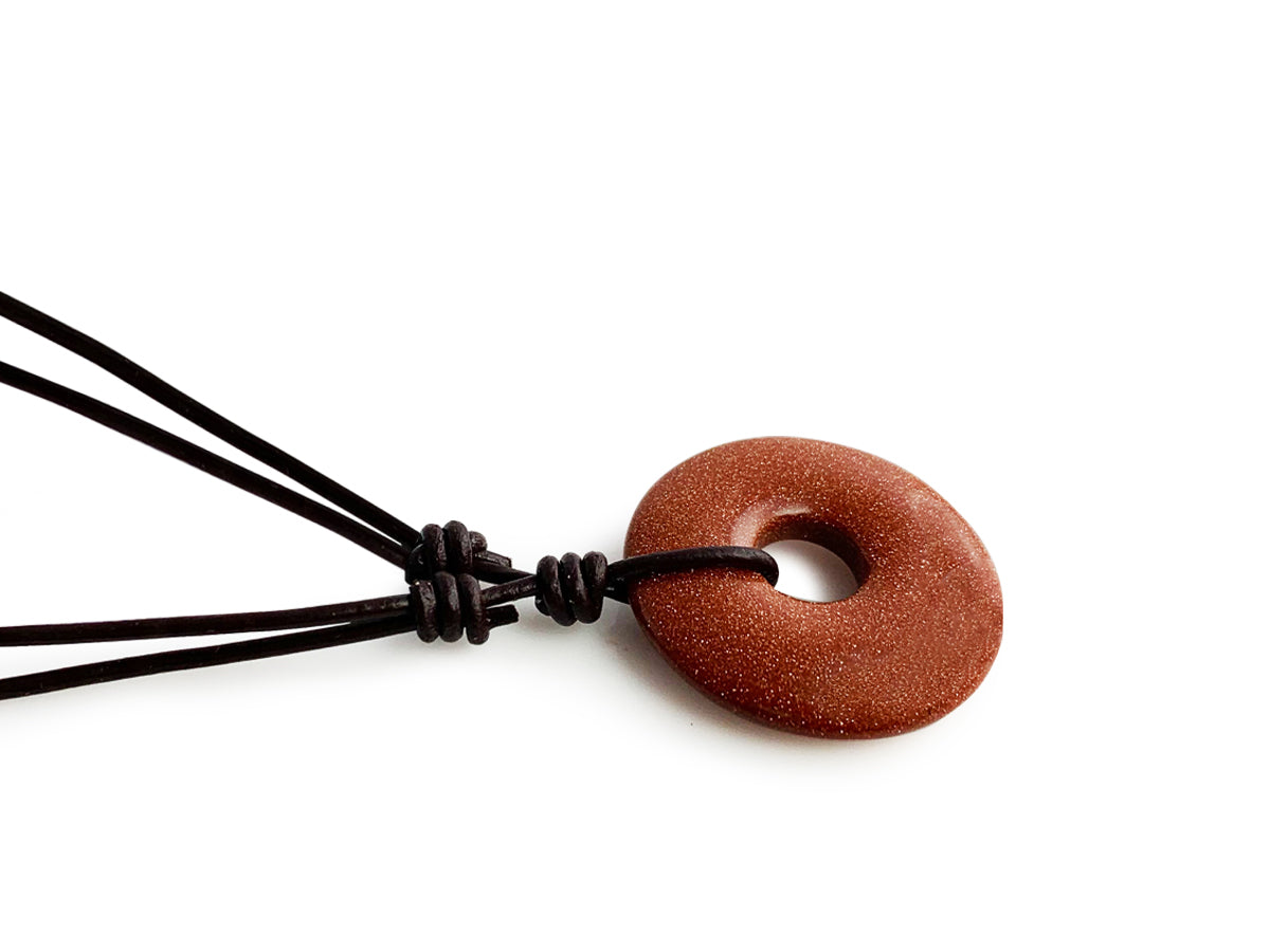 COLLAR DE CUERITO CON CENTRO DONA DE AVENTURINA DORADA.